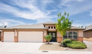 a house with two garage doors and a tree at The Palo Pinto in Alamogordo