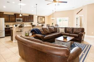 a living room with a leather couch and a kitchen at The Palo Pinto in Alamogordo