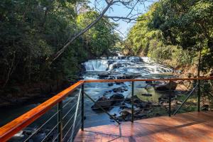 a bridge over a river with a waterfall at Pousada Estalagem de Brotas in Brotas +16 photos