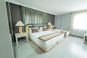 ein Hotelzimmer mit zwei Betten und einem Fenster in der Unterkunft Sever Suites Hotel in Antalya