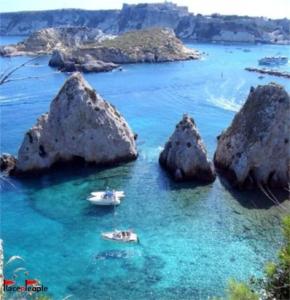 a group of rocks in the water with two boats at Imperial House in Poggio Imperiale