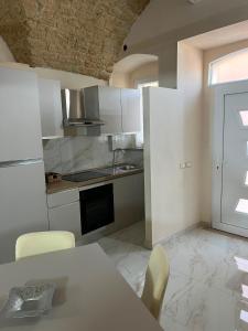 a kitchen with white cabinets and a table with chairs at Imperial House in Poggio Imperiale