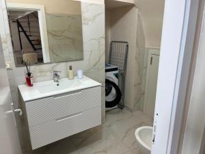 a white bathroom with a sink and a mirror at Imperial House in Poggio Imperiale +14 photos