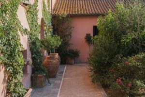 an alley with potted plants in a house at Hotel Relais Santa Genoveffa in Paganico