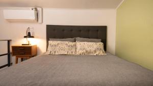 a bedroom with a large bed with a large headboard at La Joya Hostel in Valparaíso
