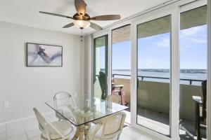 a dining room with a glass table and a ceiling fan at Two Bedroom Corner Condo with Panoramic Gulf Views in Clearwater Beach