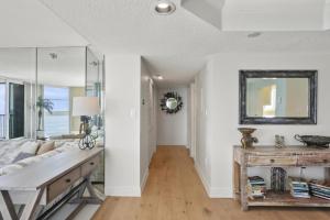 a living room with a couch and a mirror at Two Bedroom Corner Condo with Panoramic Gulf Views in Clearwater Beach +14 photos