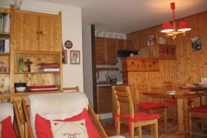 a kitchen with wooden walls and a table and chairs at Family mountain retreat with breathtaking views in Le Monêtier-les-Bains