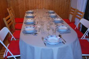 a table with blue and white plates and wine glasses at Family mountain retreat with breathtaking views in Le Monêtier-les-Bains