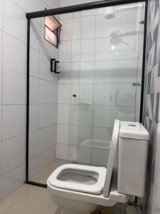 a bathroom with a white toilet and a shower at Pousada SMART AIRPORT 10 min GRU in Guarulhos
