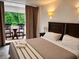 a bedroom with a bed and a balcony with a table at Kalken Hotel by MH in El Calafate