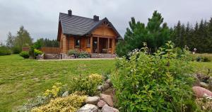 a wooden house with a garden in front of it at Chata Krusznia in Giby