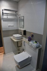 a bathroom with a white toilet and a sink at Hotel Ramayana in Ellora