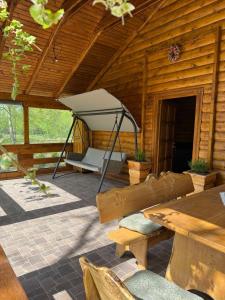 a porch of a wooden cabin with a hammock at Brvnara Dina in Železnička Stanica Dolovo