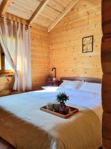 a bedroom with a bed with a tray on it at Brvnara Dina in Železnička Stanica Dolovo