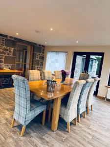 a dining room with a wooden table and chairs at Burnside Holiday Cottage 2 in Fochabers