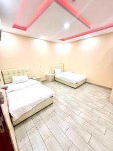 two beds in a large room with a ceiling at شاليهات زارا Zare in Taif