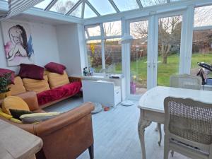 ein Wohnzimmer mit Sofa und Tisch in der Unterkunft Firefly Studio in Holt