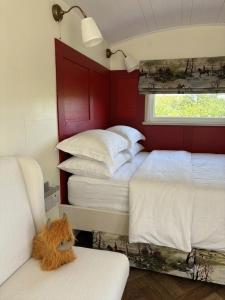 a bedroom with two beds and a window and a chair at Blackthorn and Rose Shepherds Huts in Scribbagh