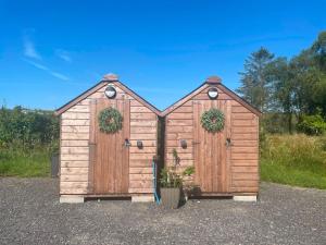 a wooden shed with two doors with wreaths on it at Blackthorn and Rose Shepherds Huts in Scribbagh