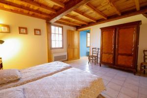 a bedroom with two beds and a wooden ceiling at Location Le Penan in Léon