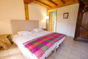 a bedroom with a bed with a colorful blanket at Location Le Penan in Léon +2 photos