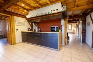 a large kitchen with a counter and a microwave at Location Le Penan in Léon
