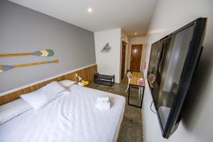 a bedroom with a bed and a flat screen tv at URB Hotel in Fortaleza