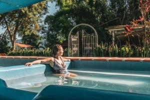 a woman is sitting in a swimming pool at Cozy Apartment in Minca in Minca