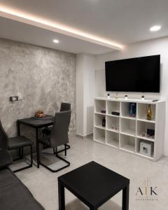 a living room with a table and a flat screen tv at ATK apartment in Koper