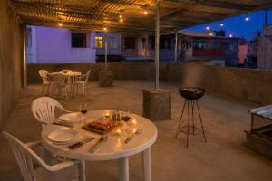 a white table with a plate of food and glasses of wine at Praia City Apartments in Praia