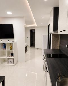 a kitchen with white walls and a tv on a counter at ATK apartment in Koper
