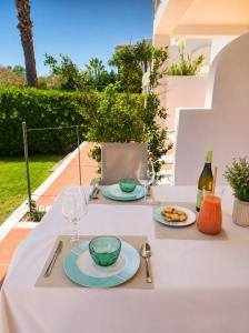 a table with two plates of food and wine glasses at Bela Ria Waterfront House Pool & Boat to Beach in Cabanas de Tavira