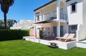 a white house with a patio and a lawn at Bela Ria Waterfront House Pool & Boat to Beach in Cabanas de Tavira