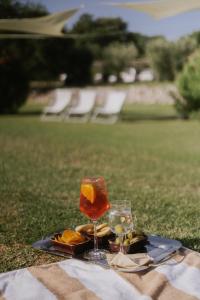 a plate of food and two glasses on a table at Hotel Relais Santa Genoveffa in Paganico