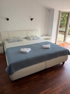 a bedroom with a large bed with two towels on it at Vila Srna in Petrovac na Moru