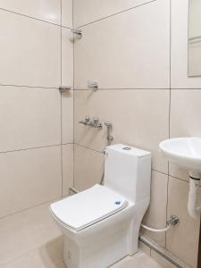 a white bathroom with a toilet and a sink at AIDAN RESIDENCY - AC Premium Rooms in Alwaye