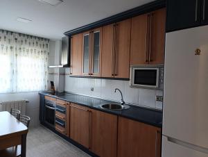 a kitchen with wooden cabinets and a sink at Fuenteazul in Hortigüela