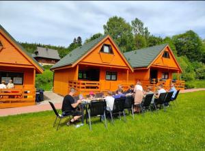 a group of people sitting at a table in front of a house at Domki na Podgórzu in Duszniki Zdrój +25 photos