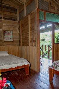a bedroom with a bed and a large window at Oski Lodge, Rain Forest Rincón de la Vieja in Upala