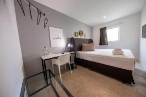 a bedroom with a bed and a desk in it at URB Hotel in Fortaleza