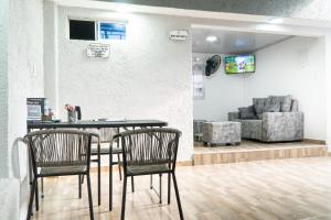 two chairs and a table in a room with a couch at Hotel Tayronaka in Santa Marta