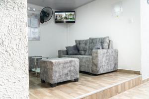 a living room with a chair and a ottoman at Hotel Tayronaka in Santa Marta