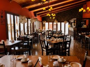 a restaurant with wooden tables and chairs and windows at Kalken Hotel by MH in El Calafate