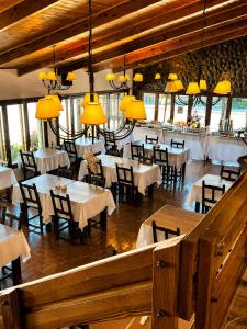 a dining room with tables and chairs and chandeliers at Kalken Hotel by MH in El Calafate