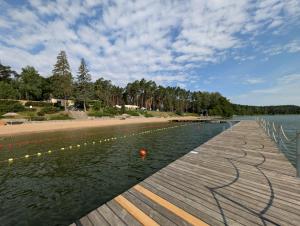 a wooden pier next to a beach and the water at Apartament Żurawie in Jastrowie