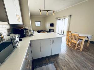 a kitchen with a counter and a table in it at Family Garden Suite - Sleeps 4 in Pretoria