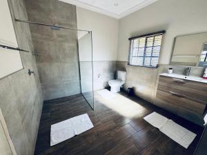 a bathroom with a shower and a toilet and a sink at Family Garden Suite - Sleeps 4 in Pretoria