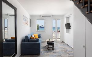 a living room with a blue couch and a table at Limen Port View Studio in Tinos
