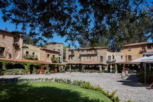 a courtyard with a large building with a green lawn at Staybridge Suites Puebla by IHG in Puebla